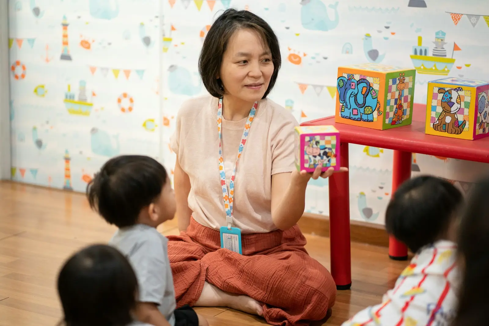 Early childhood educator sitting with young children