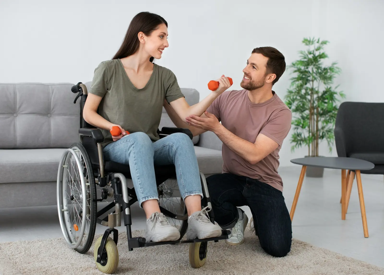 Support worker helping a woman in a wheelchair with an exercise