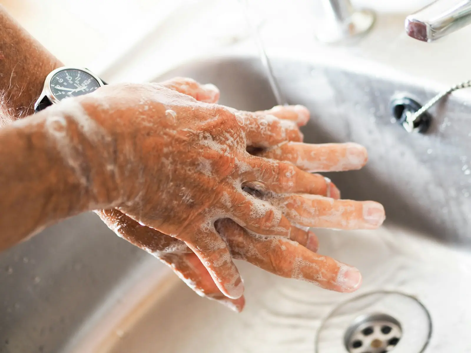 Hands lathered with soap at a sink