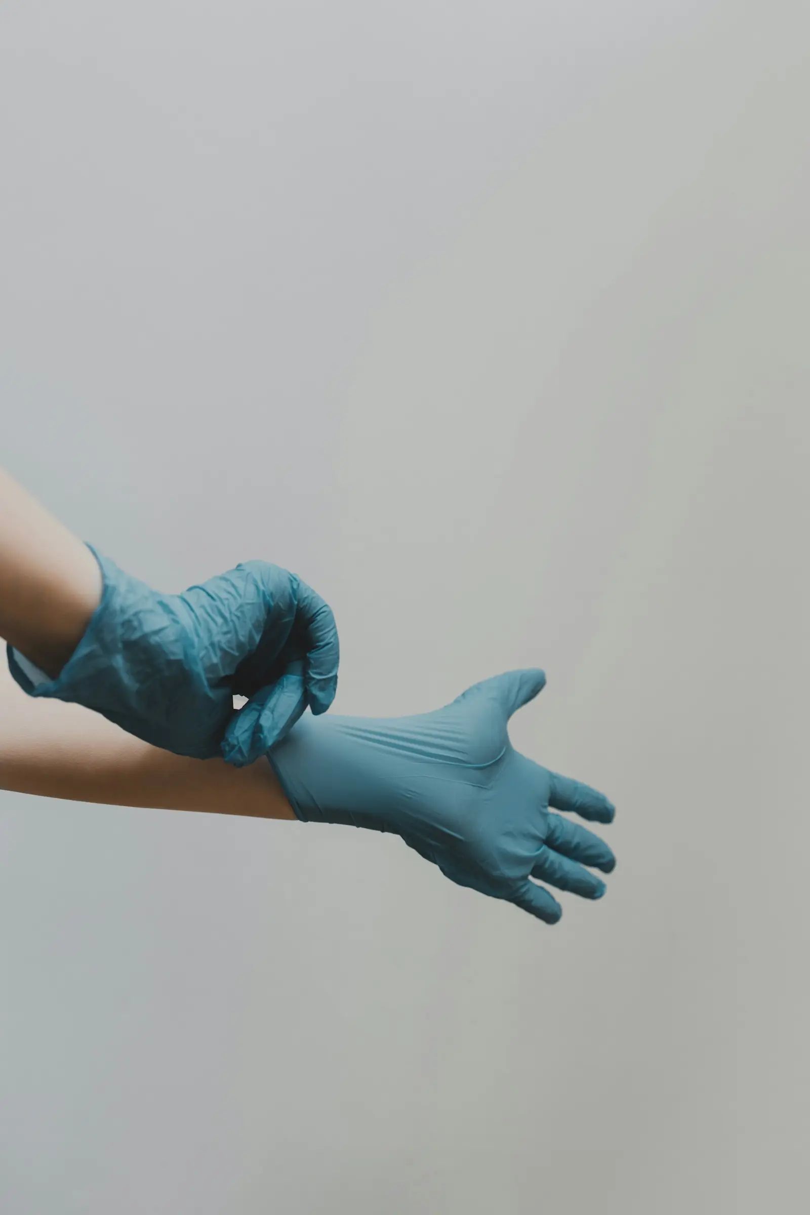 Pulling on a blue nitrile glove