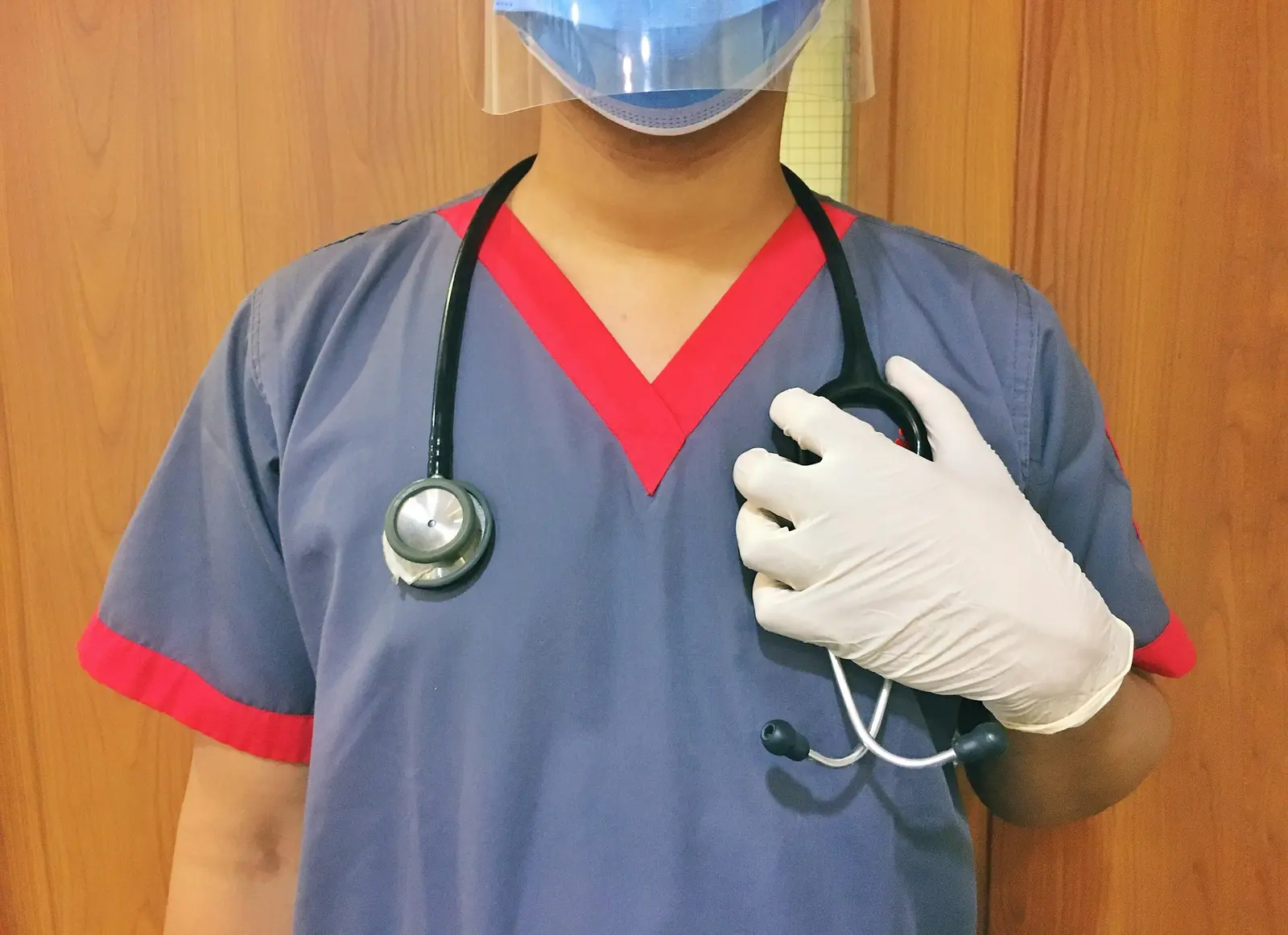 Health worker in scrubs, mask and gloves